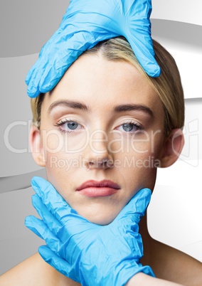 Gloved hands on woman's face against white texture