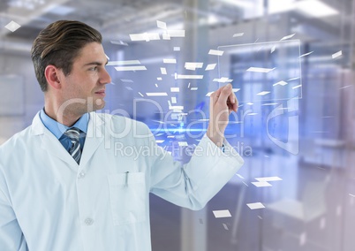 Man in lab coat holding up glass device against blue interface and blurry lab