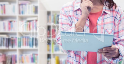 Womans hands holding tablet in Library