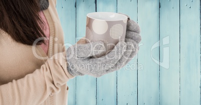 Close up of woman with polka dot mug against blue wood panel