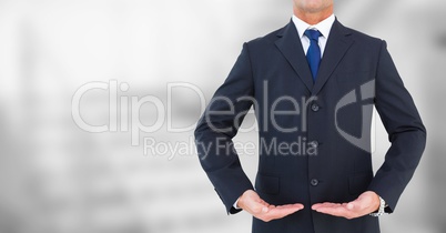 Business man mid section with palms up against blurry grey stairs