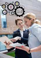 Two business women with devices and black gear graphics