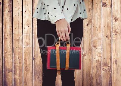 Woman's legs with handbag against wood panel