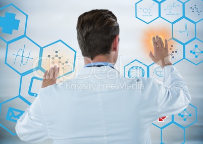 Back of man in lab coat touching blue medical interface with orange flares against grey background