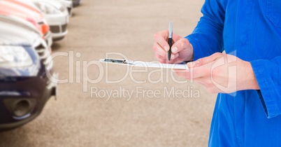 Mechanic with clipboard in blurry carpark