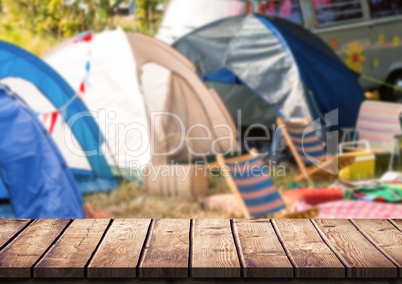 Wood table against blurry campsite