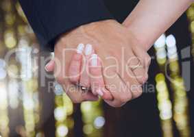 Wedding couple holding hands in forest woods