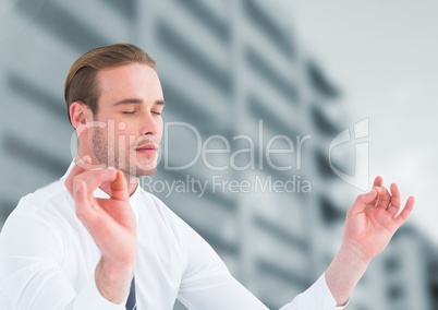 Businessman Meditating by office buildings