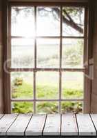 White wood table against blurry window with flare