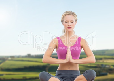 Woman Meditating by green fields