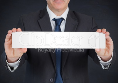 Business man with blank card against navy chalkboard