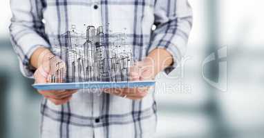 Man mid section with tablet and sketch of building against blurry grey room