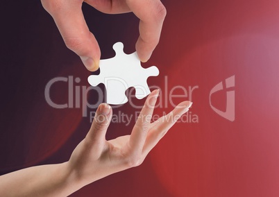 Hands holding jigsaw piece helping against red background
