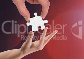 Hands holding jigsaw piece helping against red background