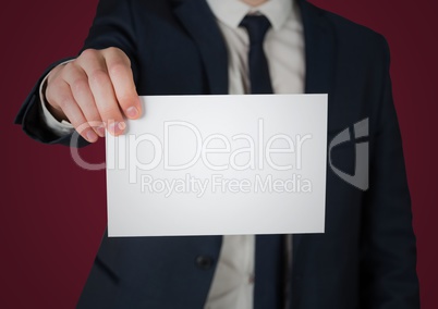 Business man holding out blank card against maroon background