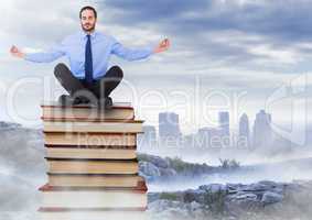 Businessman sitting meditating on Books stacked by distant city