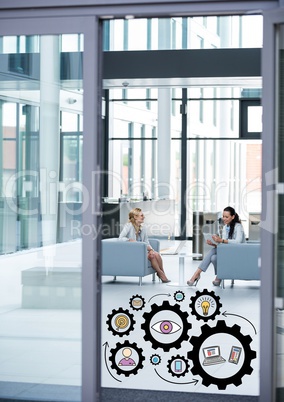 Two business women in office with black gear graphics