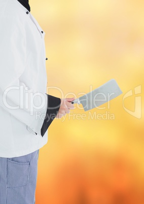 Chef with cleaver against blurry orange background