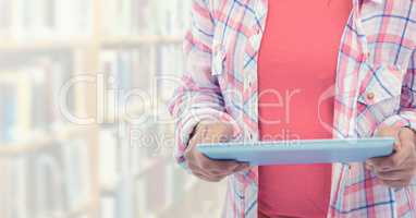 Womans hands holding tablet in Library