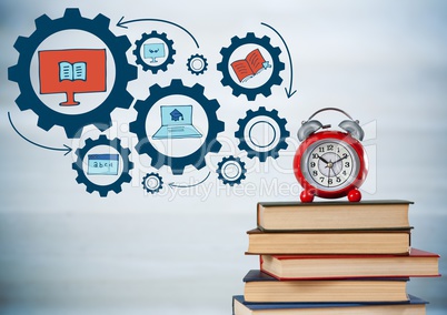 Pile of books and clock with blue gear graphics against blurry grey wood panel