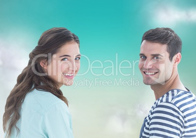 Couple looking over shoulders against blue green background with clouds