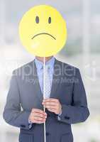 Sad businessman holding face against blurred bright background