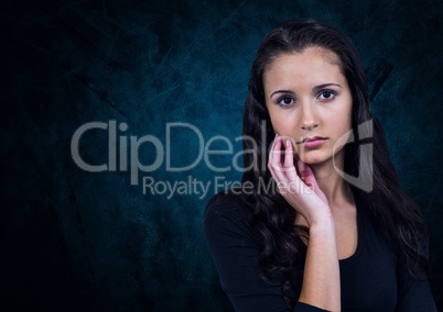 Unhappy doubtful woman against dark blue background