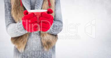 Woman mid section with red mug against white wall