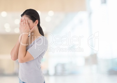 Sad woman grief hands over face against bright background