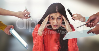 Stressed woman surrounded by phones and files and tablet in office