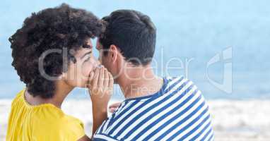 Couple whispering against blurry beach