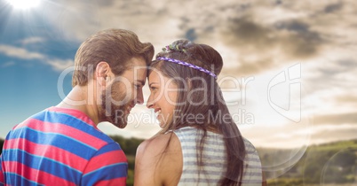 Hippie couple with flare against sky and hills