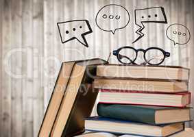 Pile of books and glasses with black speech bubbles against blurry wood panel