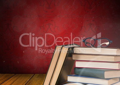 Books stacked by red rustic wall