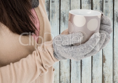 Close up of woman holding polka dot mug against wood panel