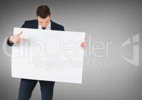 Business man with large blank card against grey background