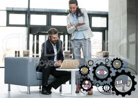 Business man and woman looking at laptop with black gear graphics