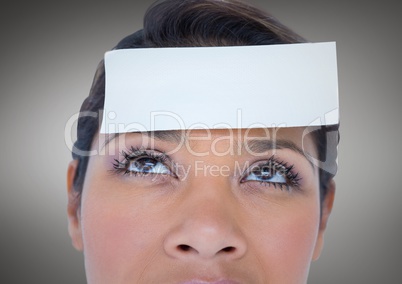 Close up of Woman with card on head against grey background