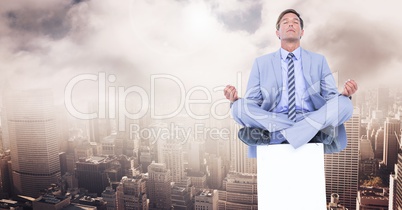 Businessman Meditating on plinth over city