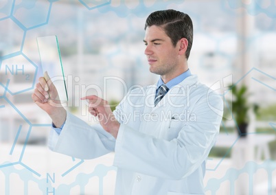 Man in lab coat holding up glass device against blue medical interface and blurry office