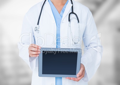 Doctor mid section with tablet against blurry background