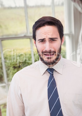 Businessman worried crying against countryside window
