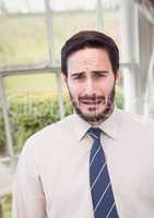 Businessman worried crying against countryside window