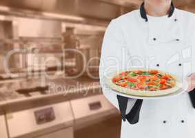 Chef with pizza against blurry kitchen with orange overlay