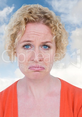 Sad woman crying against blue sky