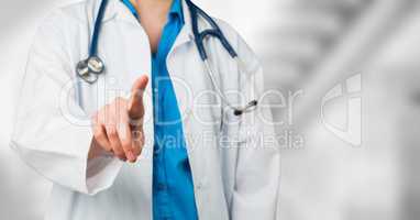 Doctor mid section pointing against blurry background