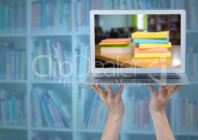 Hands with laptop showing book pile against blurry bookshelf with blue overlay