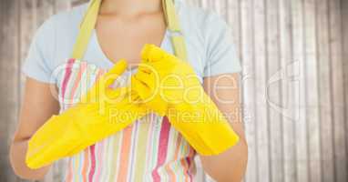 Woman in apron with gloves against blurry wood panel