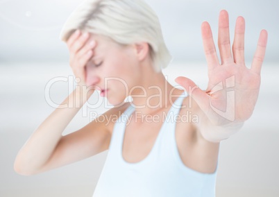 Sad stressed woman holding out hand against bright background