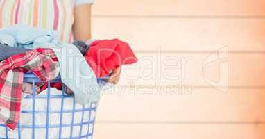 Woman in apron with laundry against blurry orange wood panel